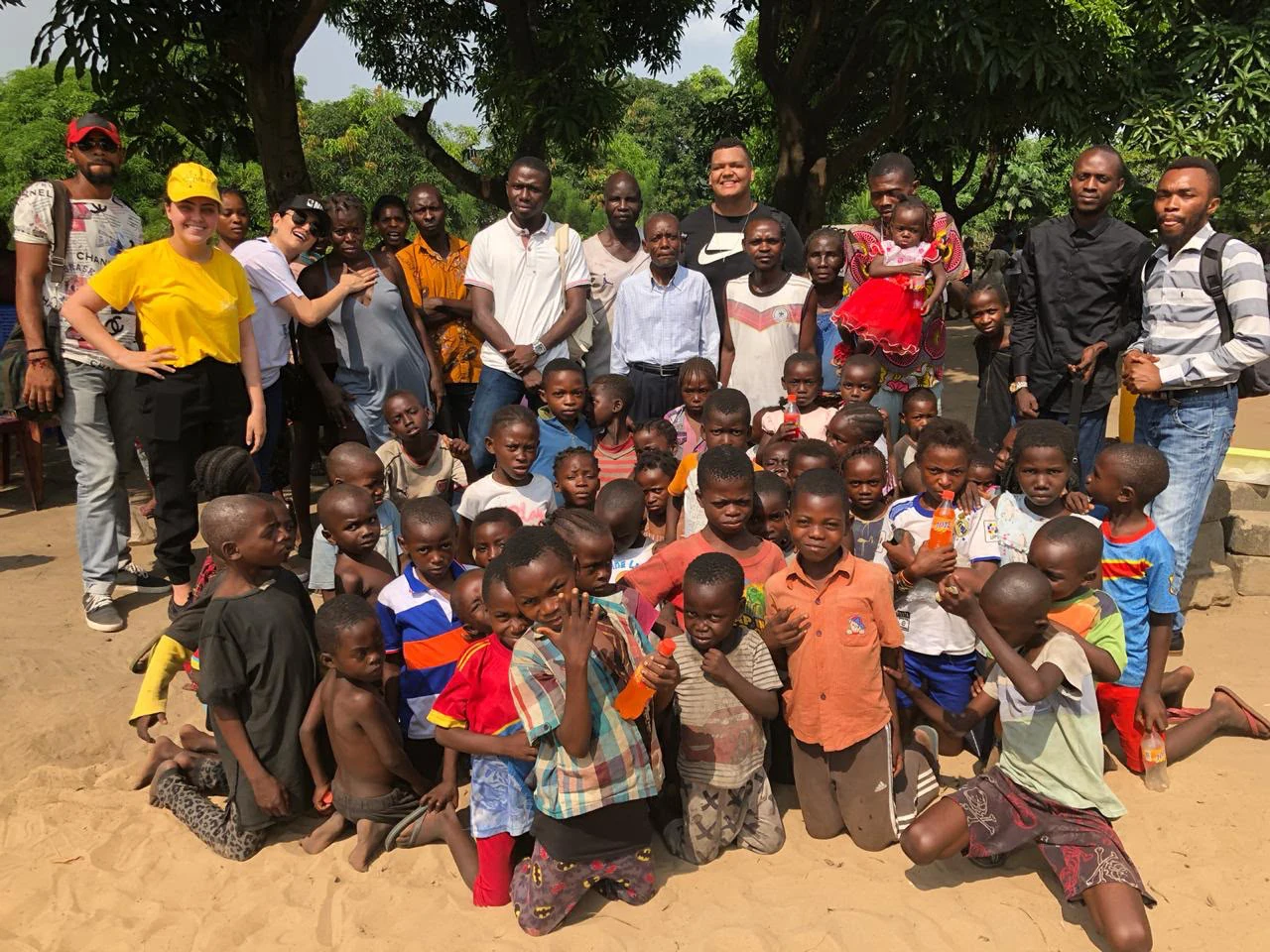 Equipe e crianças reunidas durante uma ação comunitária da MBA Maluta Foundation